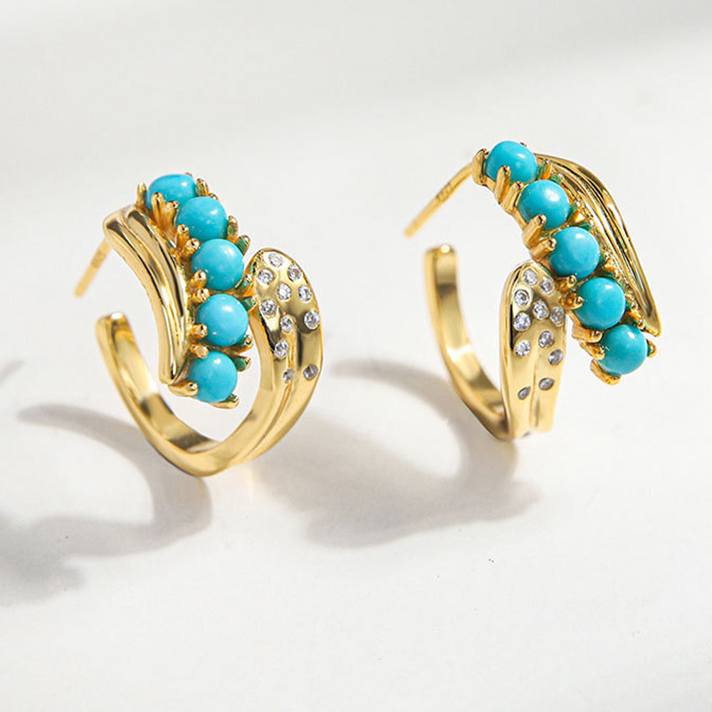 Gold plated hoop earrings with turquoise beads and small crystal accents on white background