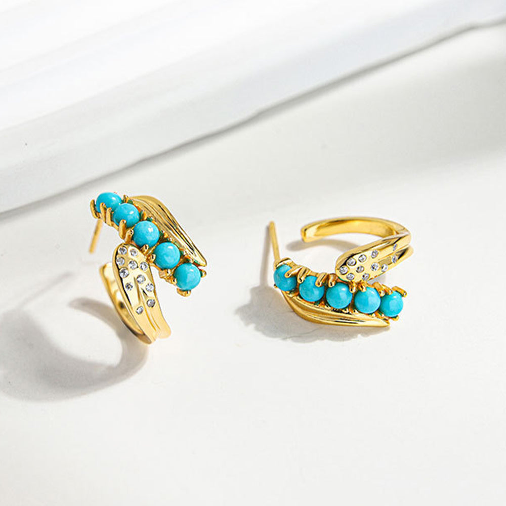 Pair of gold plated earrings featuring turquoise beads and small crystal accents on white background