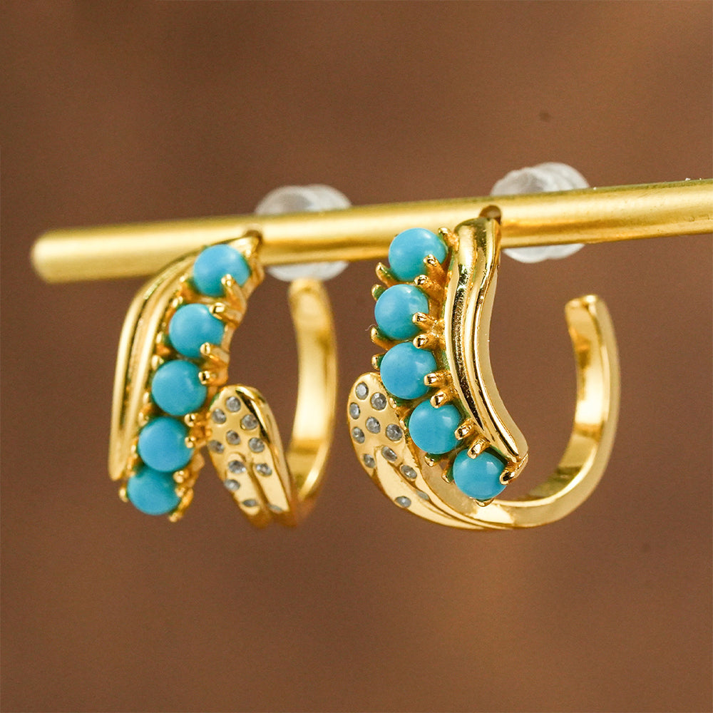 Gold plated hoop earrings with turquoise gemstone beads and small crystal accents on a display rod