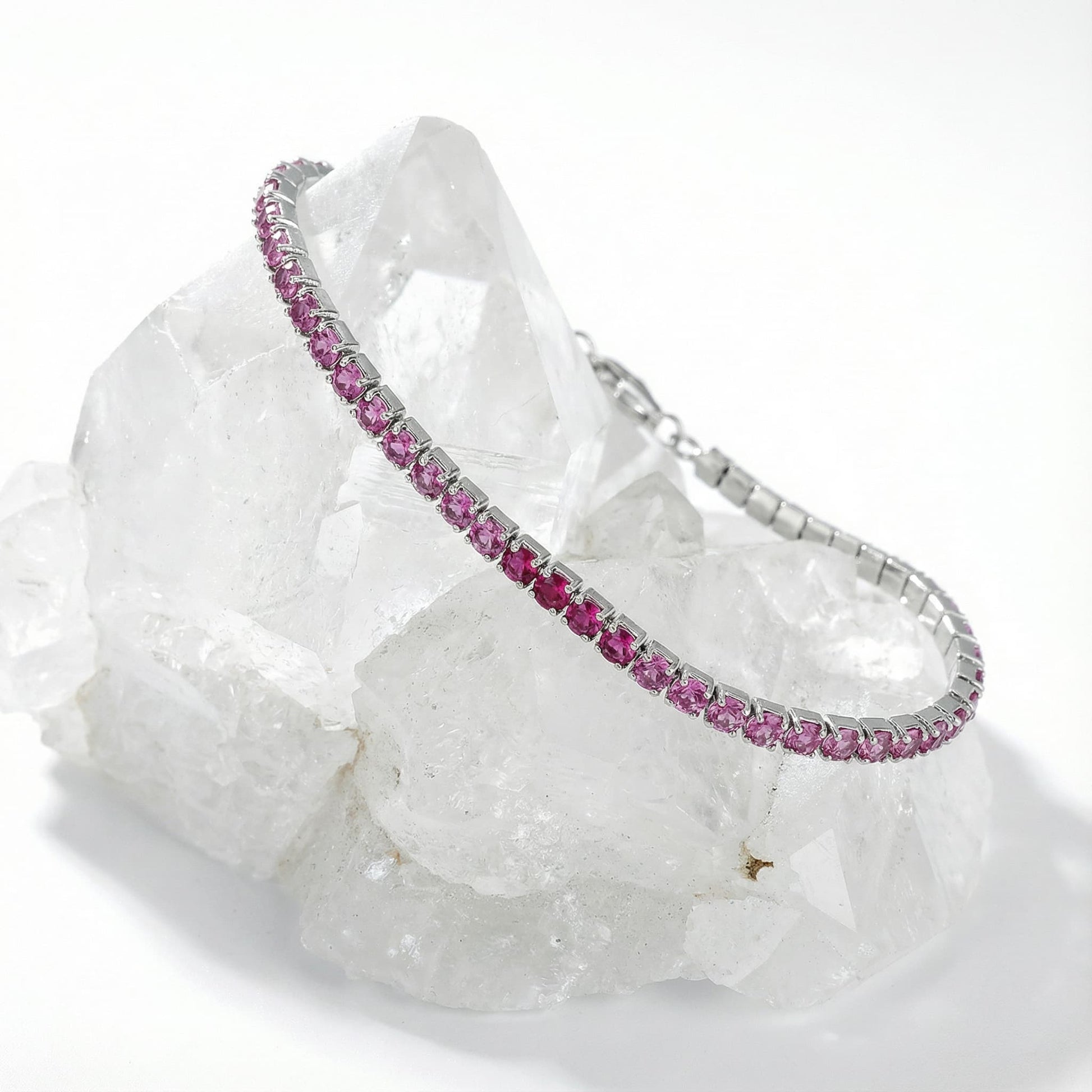 Silver bracelet with pink gemstones displayed on clear quartz crystal cluster